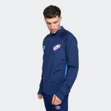 Buzo deportivo Umbro de entrenamiento del Club Nacional de Football, color azul marino, manga larga, con cuello alto y cierre frontal parcial. Presenta el logo de Umbro y el escudo del club.