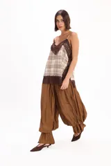 Pantalón negro de corte amplio, con cintura elástica fruncida y diseño abombacho con volados en los tobillos.