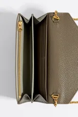 Minibolso billetera de piel color rosado, con cierre de solapa y broche a presión. Incluye bolsillo exterior y asa bandolera de cadena con logo Chimo. El interior cuenta con monedero y tarjetero. Exterior personalizado con logo Bimba y Lola estampado en dorado.