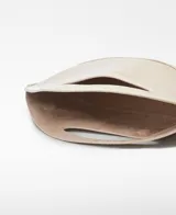 Bolso de mano de la marca Renacer Lab, color beige brillante, con un compartimento principal, cierre magnético y asa de mano. El logo de la marca está grabado en el frente.