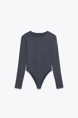 Body de manga larga confeccionado en mezcla de poliamida, con cuello redondo y cierre inferior con botones a presión.
