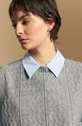 Chaleco tejido de punto en color azul marino, con diseño de textura sutil en relieve, escote redondo y terminaciones acanaladas en cuello, sisas y ruedo.