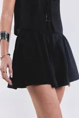 Short pollera negro de estilo plisado con cremallera en el costado.