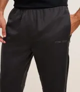 Pantalón deportivo gris oscuro con cintura elástica, bolsillos con cremallera, textura y estampa lettering.