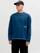 Buzo azul marino de manga larga con cuello redondo, confeccionado en tejido de punto rizo de algodón con costuras decorativas en color blanco y detalle de logo estampado en el pecho.