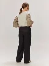 Remera blanca con cuerpo de algodón liso y mangas abullonadas semitransparentes con textura de lunares.