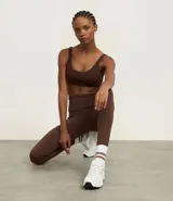 Legging deportivo de tiro alto en color marrón chocolate, confeccionado en tejido de poliamida con elastano, con diseño ajustado y cintura texturizada.