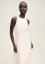 Vestido midi evasé color blanco hueso, sin mangas y cuello halter.