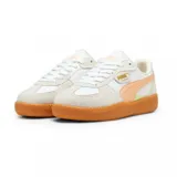 Championes Puma modelo Palermo, con diseño retro de perfil bajo. Presentan una combinación de cuero blanco y gamuza en tonos claros, con detalles en rosa pálido y una suela de goma color caramelo. Incluyen el logo de la marca en dorado en el lateral.