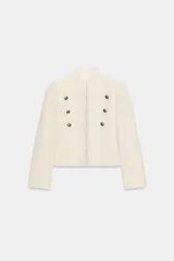 Chaqueta estilo militar ZW Collection confeccionada en hilatura con mezcla de algodón, color crudo, con cuello subido, manga larga, falsos bolsillos de vivo y cierre frontal con ganchos metálicos y botones decorativos dorados.