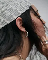 Aros de plata 950 con diseño de silueta orgánica y cierre integrado en línea continua.