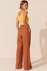 Pantalón de vestir de corte recto y tiro alto, con pinzas frontales y aberturas laterales en el ruedo.