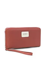 Billetera larga con cierre perimetral, confeccionada en material sintético texturizado color mostaza. Cuenta con correa de mano extraíble y placa metálica con logo de la marca en el frente.