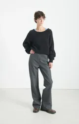 Polerón de punto negro con textura esponjosa, corte holgado y mangas largas. Presenta un diseño de cuello redondo y acabado suave al tacto.