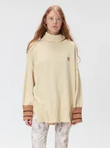 Pullover de cuello tortuga color marrón, de corte holgado y diseño básico. Presenta puños acanalados en contraste de color bordó con líneas horizontales celestes.