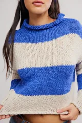 Sweater de punto grueso a rayas anchas azules y beige, de calce corto y amplio, con cuello alto vuelto y mangas caídas.