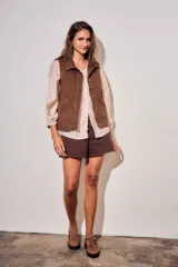 Chaleco oversize de algodón color marrón con efecto lavado, cuello solapa y cierre frontal con botones metálicos. Cuenta con bolsillos frontales diagonales.