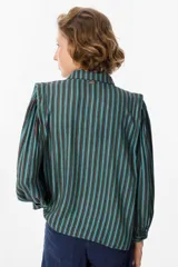 Camisa de manga larga con diseño de rayas verticales en tonos verde, azul y marrón. Presenta cuello clásico, cierre frontal con botones y mangas abullonadas con puños ajustados.