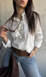 Camisa blanca de manga larga con detalles de broderie y calados en el frente y las mangas.