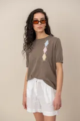 Sweater Dins Tricot beige de manga corta y cuello redondo, con detalle de rombos bordados en colores pastel en el frente.