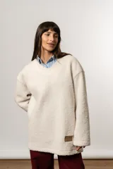 Buzo oversize color crudo, de tela tipo corderito, con escote en V.