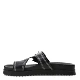 Sandalias negras Miss Carol modelo Funi, estilo dedo con plataforma baja y suela dentada. Cuenta con una tira ancha cruzada ajustable mediante una hebilla metálica grande y detalles de costuras blancas a la vista.