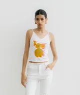 Musculosa blanca ajustada con tirantes finos y escote en V, con estampado frontal abstracto en tonos naranjas y amarillos.