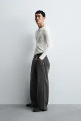 Jeans de denim de algodón, color azul oscuro con efecto lavado. Presentan un corte muy holgado (baggy fit) en toda la pierna y tiro medio. Tienen cinco bolsillos y cierre frontal con cremallera y botón.