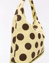 Cartera tipo tote bag de lona color beige con estampado de lunares marrones, con asa de hombro integrada.