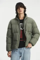 Campera puffer de corte estándar, color verde oliva, con cierre frontal completo, cuello alto y bolsillos laterales con cierre.