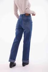 Pantalón de jean negro de corte recto, con cintura alta y ruedo doblado.