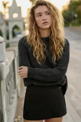 Falda pantalón de tiro medio en color gris oscuro, con diseño minimalista y detalle de cinturón fino integrado con hebilla metálica. Cuenta con cierre lateral oculto.