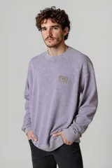 Buzo lila de corte oversize con cuello redondo y parche con logo en el pecho.