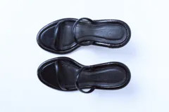 Sandalias negras de cuero con dos tiras finas y tacón de aguja.