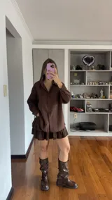 Camisa de corte oversize con estampado de rayas verticales finas, cuello clásico, cierre frontal con botones y bolsillo en el pecho.