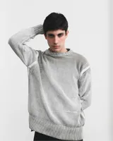 Sweater de tejido de punto color verde oliva, con cuello redondo y diseño holgado. Presenta efecto de lavado ácido y serigrafía en contraste.