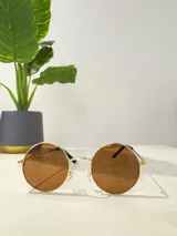 Lentes de sol con montura metálica dorada y cristales color marrón.