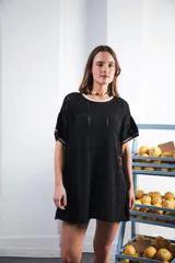 Vestido corto de tejido calado color marrón, con patrón cuadrado y logo bordado a mano en el frente. Presenta terminaciones a contratono en escote redondo y mangas cortas.