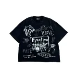 Camiseta negra de corte holgado con estampado gráfico estilo graffiti en color blanco. Presenta múltiples elementos visuales como ángeles, texto con la palabra 'Emotion', 'Hate', 'Love' y 'No Drama', además de garabatos y dibujos abstractos.