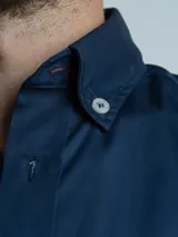 Camisa de corte regular, color terracota, de manga larga y diseño liso, con cuello camisero y cierre frontal de botones.