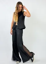 Pantalón de lino color blanco, de corte palazzo con aberturas laterales de encaje.