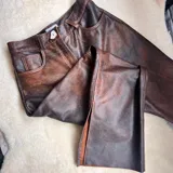 Pantalón de cuero vacuno negro, de tiro alto y corte recto con aberturas laterales en los bajos.