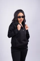 Buzo negro con cierre de media cremallera, cuello alto y logo bordado en el pecho.