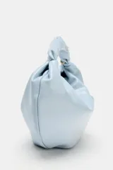 Bolso de mano celeste de diseño fruncido, con asa superior retorcida y cadena metálica dorada estilo bandolera. Cuenta con cierre de cremallera.