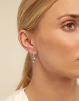 Dije de piercing dorado con forma circular y cristal celeste.