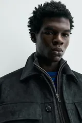 Sobrecamisa regular fit color verde oscuro, confeccionada en tejido efecto ante. Cuenta con cuello solapa, manga larga con puño abotonado, bolsillos de plastrón con solapa en el pecho y bolsillos de vivo en la cadera. El cierre es frontal con botonadura.