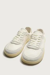 Zapatilla deportiva estilo barefoot fabricada en piel. Presenta un diseño de paneles combinados, puntera redondeada y ancha para mayor libertad de movimiento, plantilla OrthoLite extraíble y suela de goma fina en contraste.