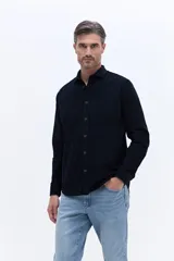 Camisa de pana de algodón con cuello clásico, cierre frontal de botones y mangas largas. Presenta un diseño de corte regular con textura suave y acabado mate.