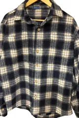 Sobrecamisa de paño a cuadros color negro y beige, con botones de madera.