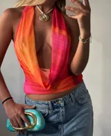 Vestido corto ajustado de microtul con estampado degradado en tonos vibrantes de naranja, fucsia y rosado. Diseño con cuello halter y escote pronunciado en cascada.